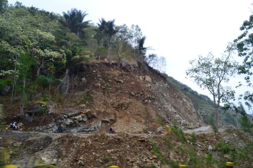 jalan dengan tebing batu yang bisa longsor ketika hujan