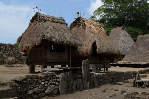 tonggak nisan manandai makam di depan bhaga